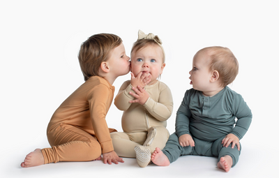 3 babies wearing Little Biscuits onesies and footies