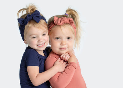 two little girls wearing their bamboo bows