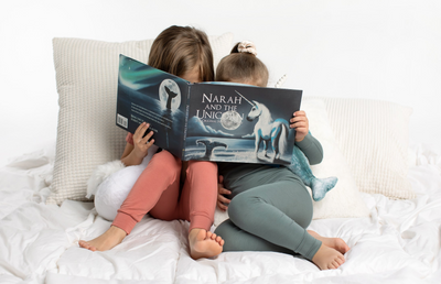 little girls looking at the Narah and the Unicorn Book